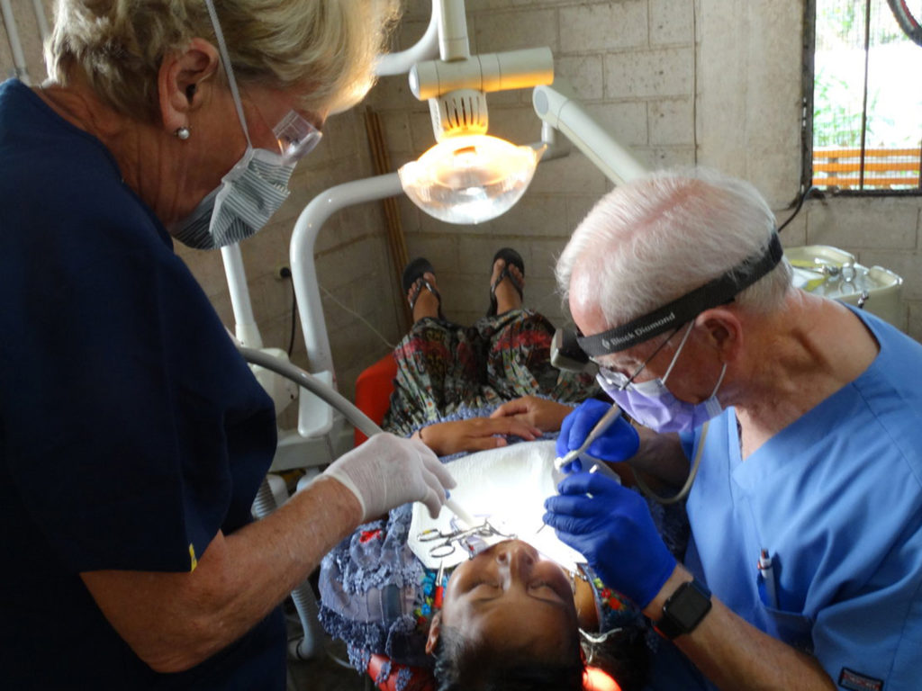 Two dentists checking a child’s mouth