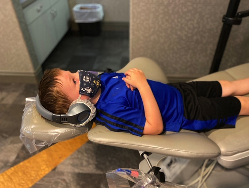 A child lying down in a dental chair